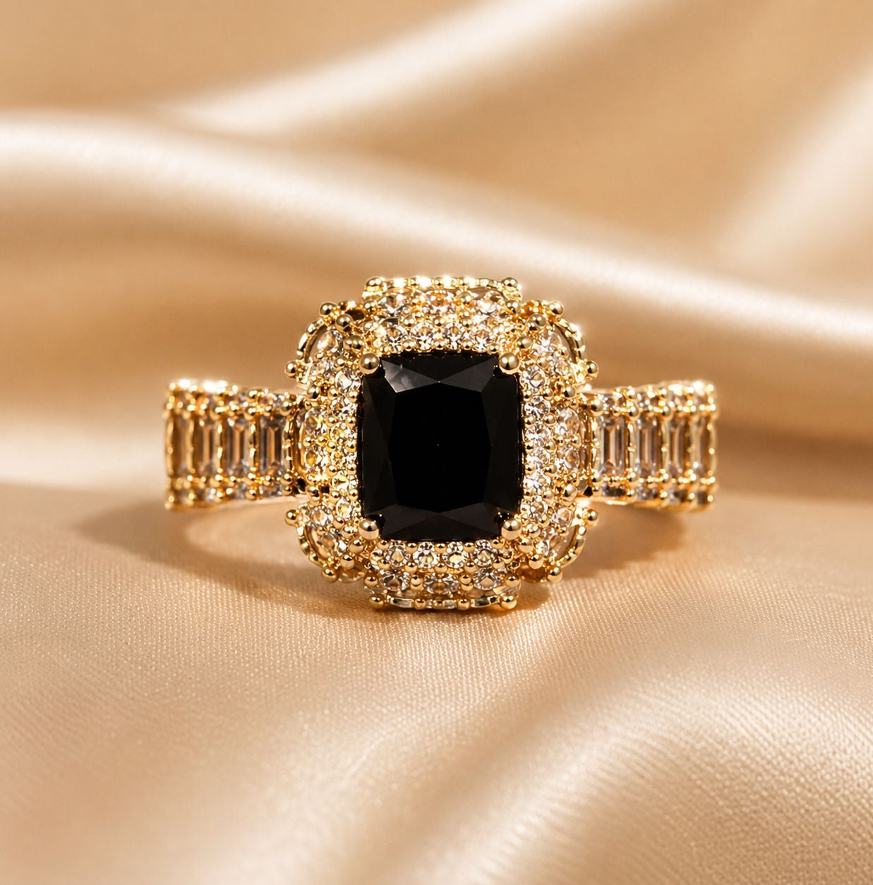 Gold ring with a central black gemstone on a beige fabric background