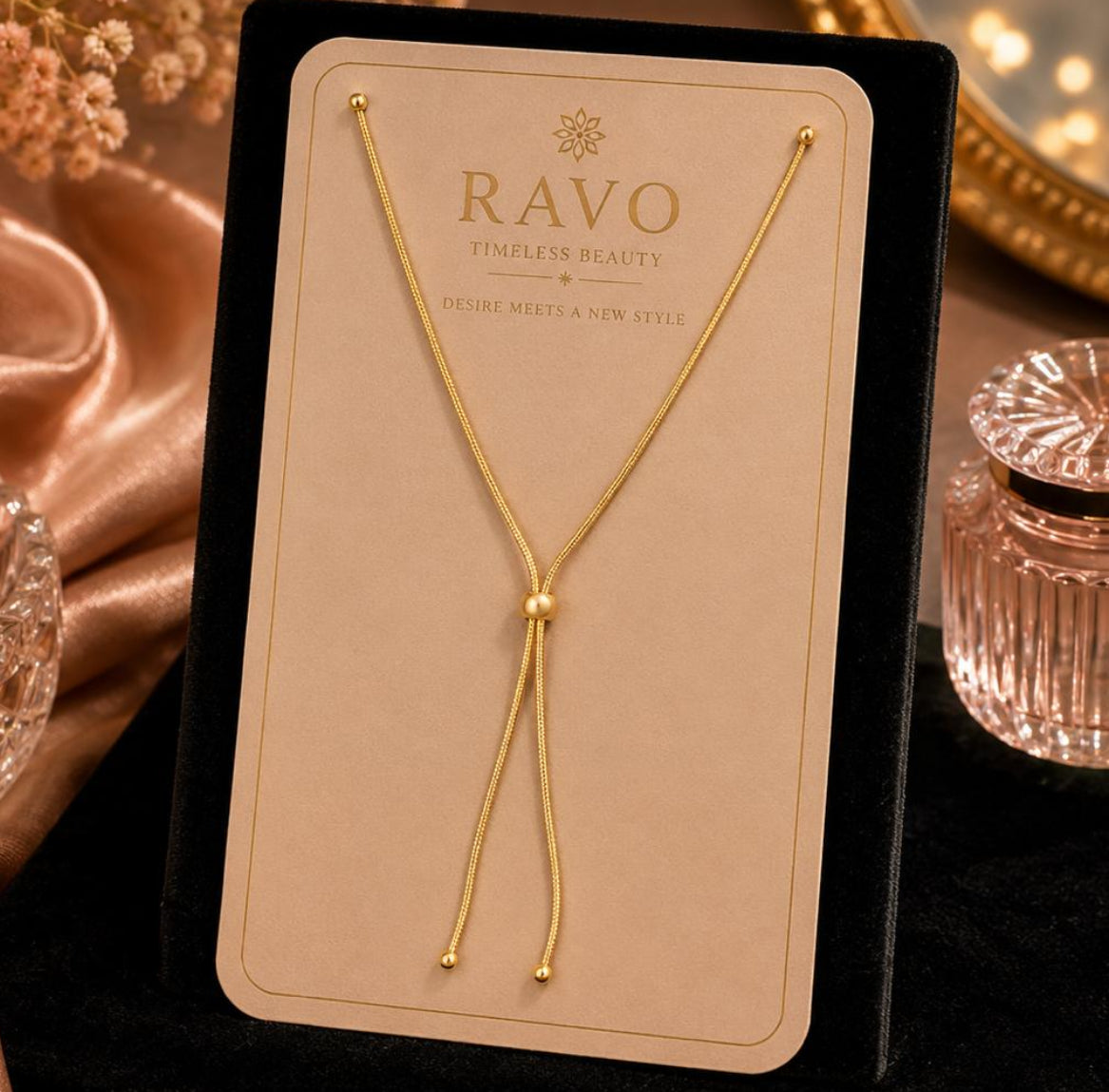 Gold necklace on a RAVO branded card with decorative background