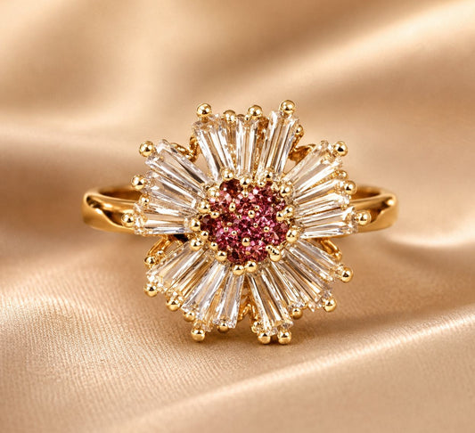 Gold ring with a pink gemstone and diamond-like stones on a beige fabric background