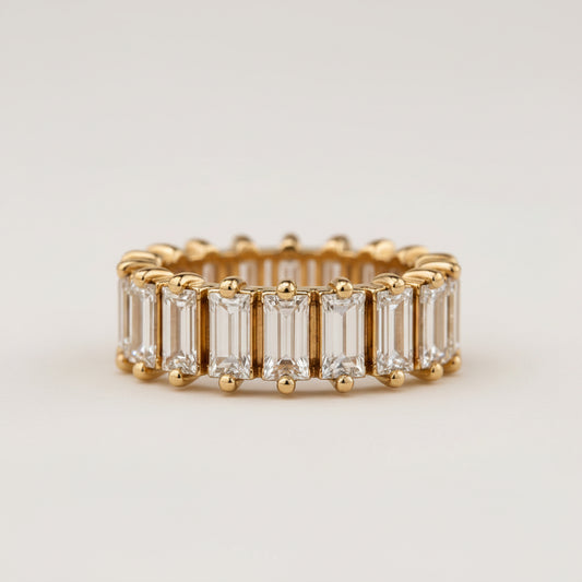 Gold ring with baguette-cut diamonds on a light beige background
